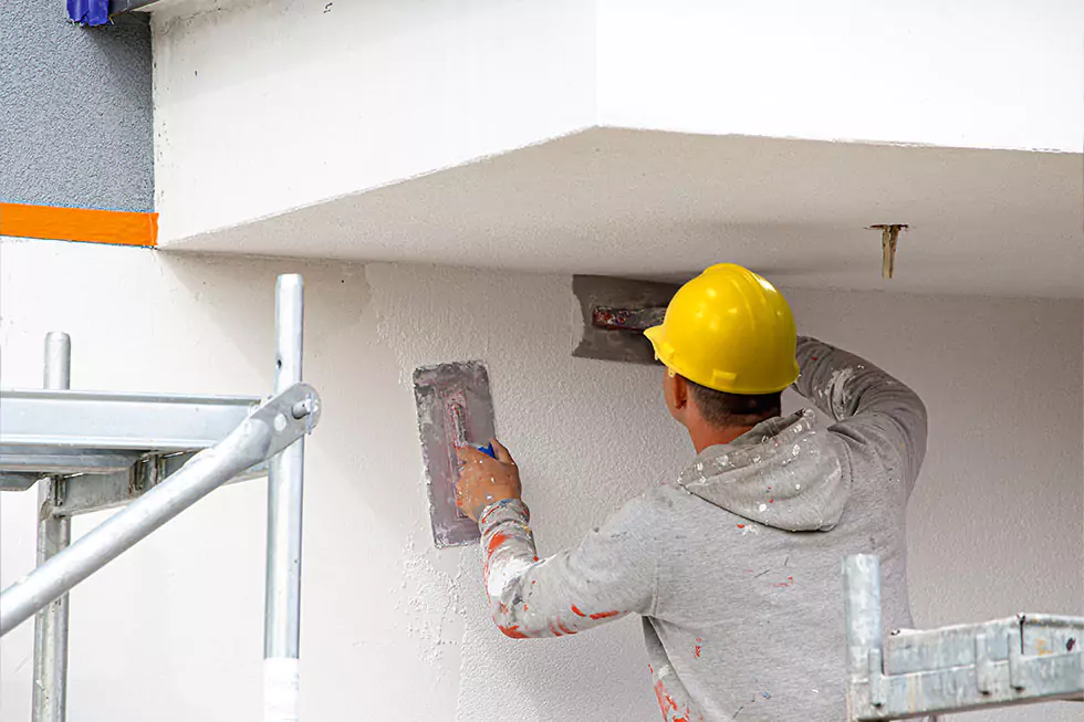 fassadenanstrich verputzen Arbeiter verputzt eine Fassade an einem Haus