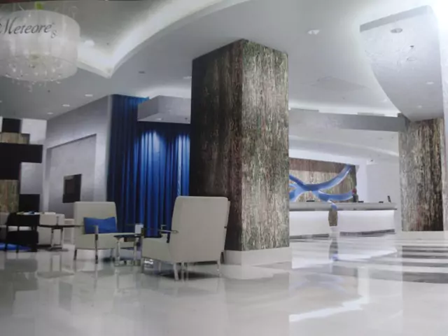 Hotel-Lounge mit exklusiver Wandgestaltung, weißen Möbeln und blauen Akzenten.