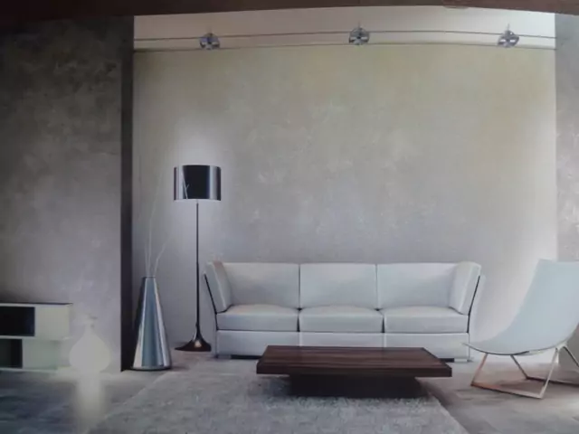 Blick in ein modernes Wohnzimmer mit Designlampe, weißen Sofa, Holztisch und Designsessel