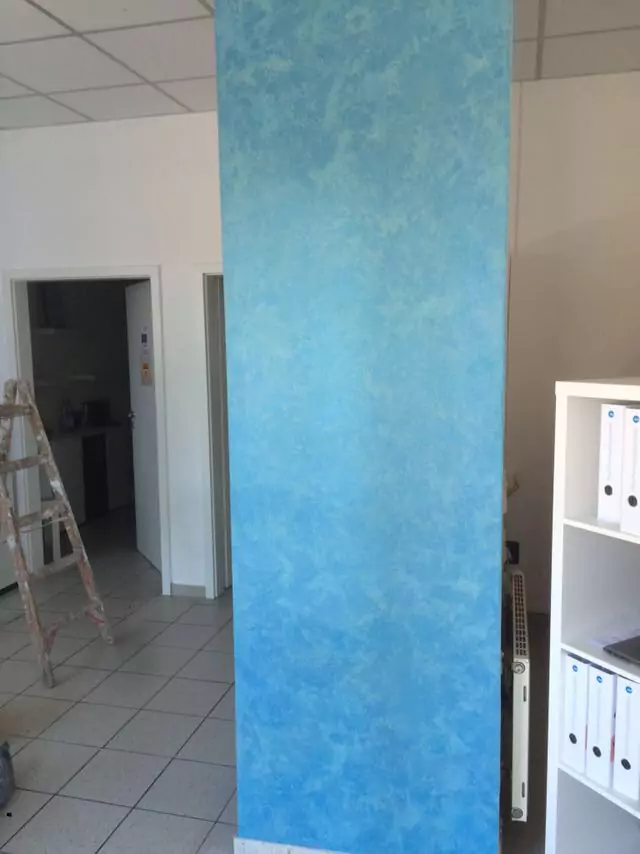 Säule mit dekorativer Wandgestaltung in blauer Spachteltechnik in einem modernen Raum.