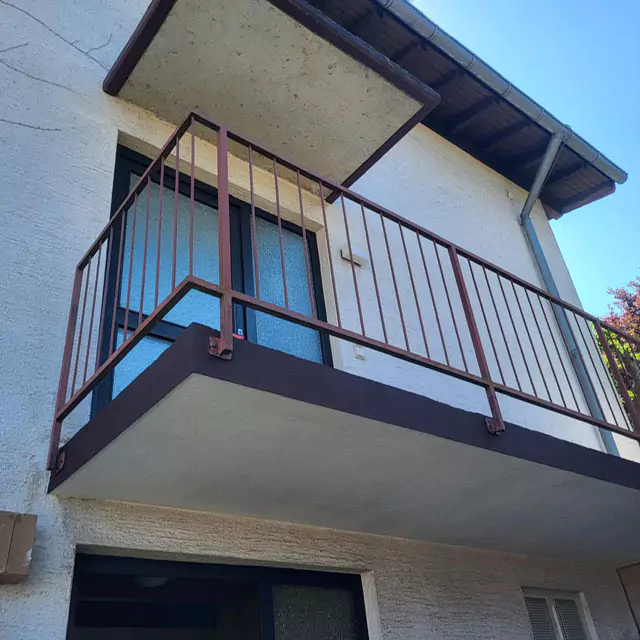 Blick von unten auf einen sanierten Balkon mit Metallgeländer