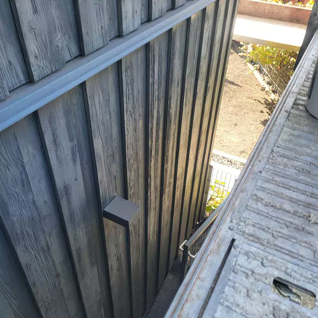 Blick vom Baugerüst auf eine Holzwand vor dem Auftragen des Holzschutzmittels