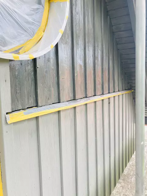 Blick vom Baugerüst auf eine Holzwand während dem Auftragen des Holzschutzmittels