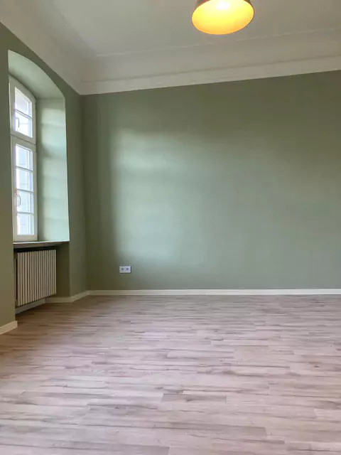Blick in einen grün gestrichenen Raum mit Deckenlampe