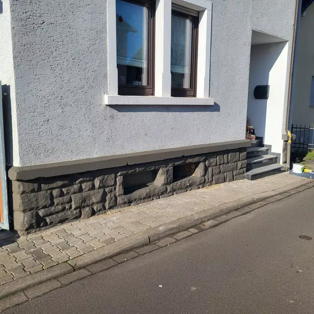 Blick auf den Sockelbereich aus Steinen eines Hauses nach der Sanierung
