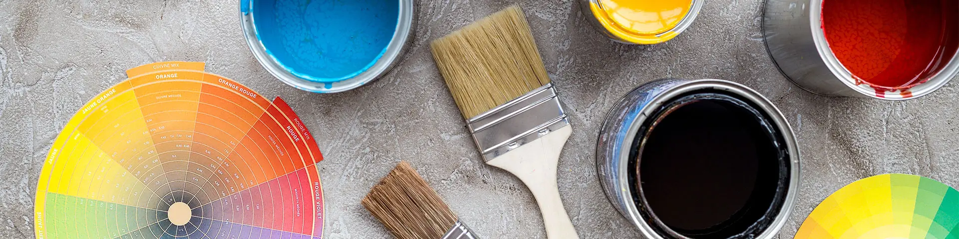 Farben in Blechdosen und Pinsel auf grauem Stein, Draufsicht